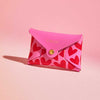 Fuchsia pink leather coin purse with red heart pattern, personalised with a name